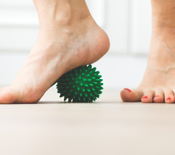 woman bare feet and green massage ball physical therapy and massage